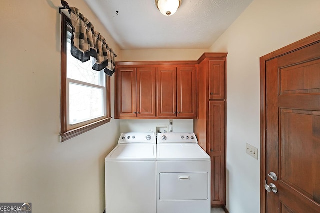 clothes washing area with cabinets and washer and clothes dryer