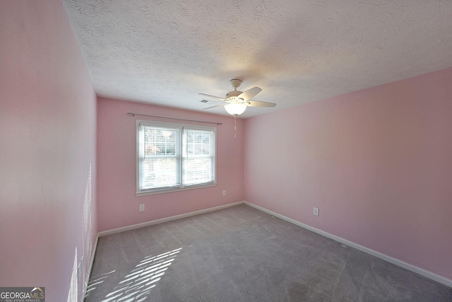 empty room with ceiling fan, carpet floors, and a textured ceiling