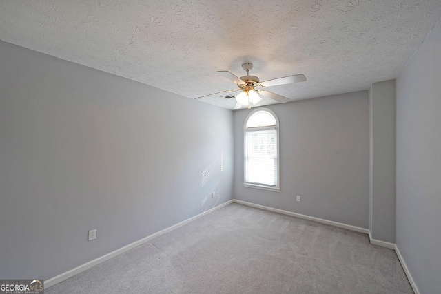 carpeted spare room featuring a textured ceiling and ceiling fan