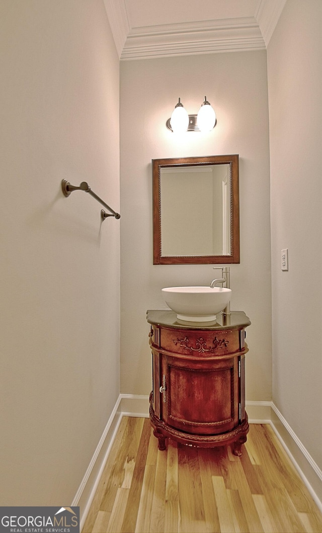 bathroom featuring vanity, hardwood / wood-style flooring, and crown molding