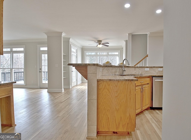 kitchen featuring sink, light hardwood / wood-style flooring, stainless steel dishwasher, ornamental molding, and a healthy amount of sunlight