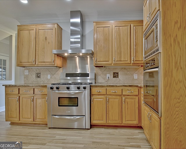 kitchen featuring stainless steel appliances, light stone countertops, ornamental molding, light hardwood / wood-style floors, and wall chimney exhaust hood