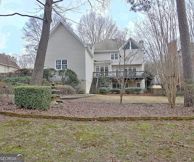 back of property with a wooden deck and a yard