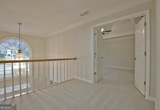 corridor with crown molding, light colored carpet, and a chandelier