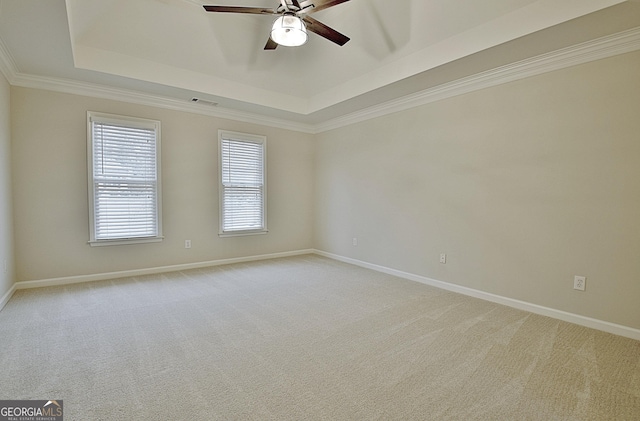 carpeted empty room featuring crown molding, ceiling fan, and a tray ceiling