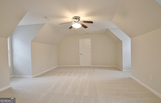 additional living space with ceiling fan, light colored carpet, and lofted ceiling