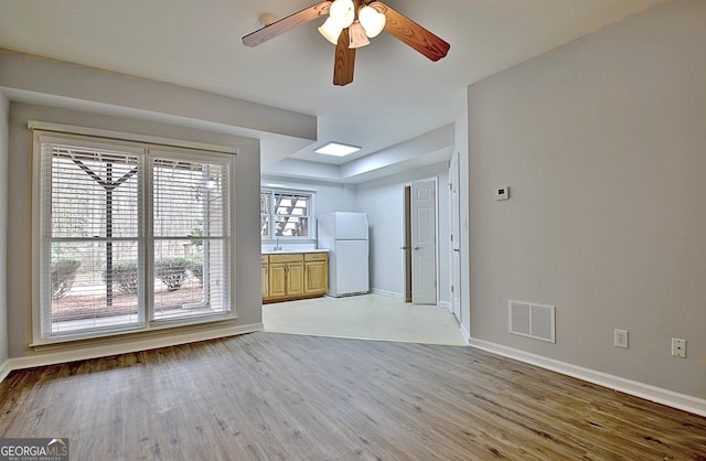 unfurnished living room featuring ceiling fan and light wood-type flooring