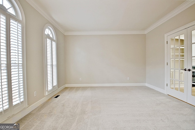 carpeted empty room featuring french doors and ornamental molding