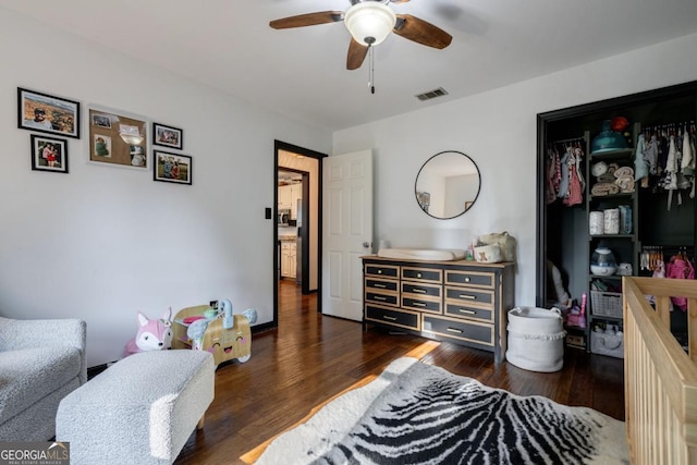 bedroom with ceiling fan, dark hardwood / wood-style flooring, and a closet