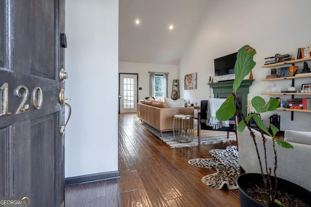 living room featuring high vaulted ceiling and dark hardwood / wood-style floors