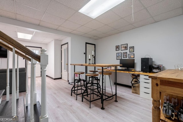 office area featuring a paneled ceiling and light wood-type flooring