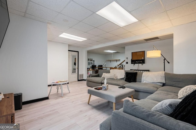 living room with a paneled ceiling and light wood-type flooring