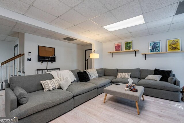 living room featuring a paneled ceiling and wood-type flooring