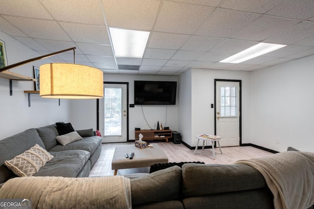 living room with light hardwood / wood-style flooring and a paneled ceiling