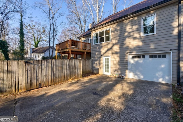 view of property exterior featuring a wooden deck and a garage