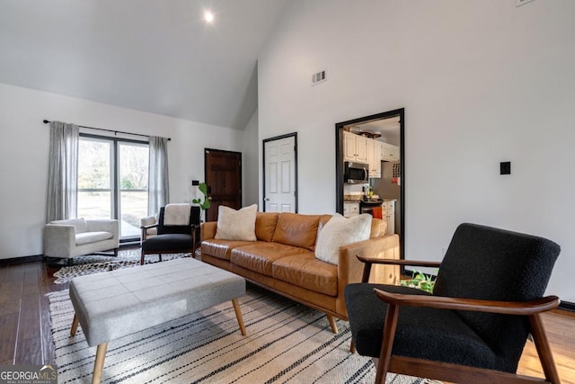 living room with hardwood / wood-style flooring and high vaulted ceiling