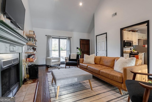 living room with high vaulted ceiling and light hardwood / wood-style floors