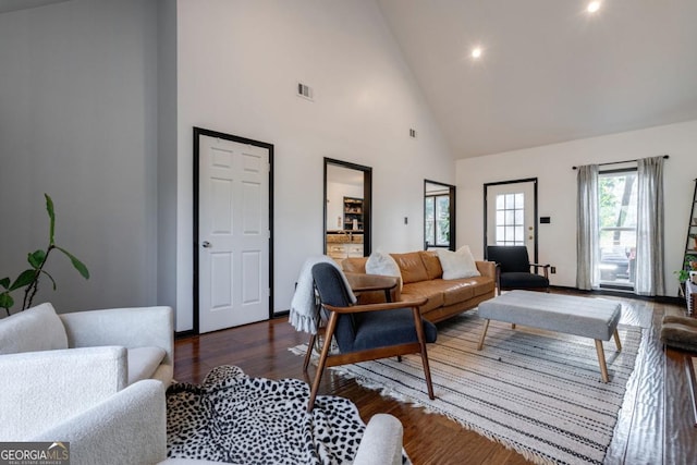 living room with dark wood-type flooring and high vaulted ceiling