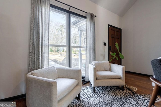 living area with hardwood / wood-style floors and vaulted ceiling