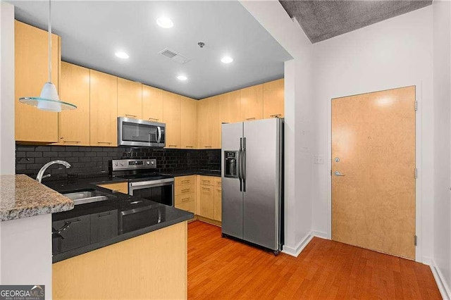 kitchen with pendant lighting, light brown cabinetry, stainless steel appliances, and sink