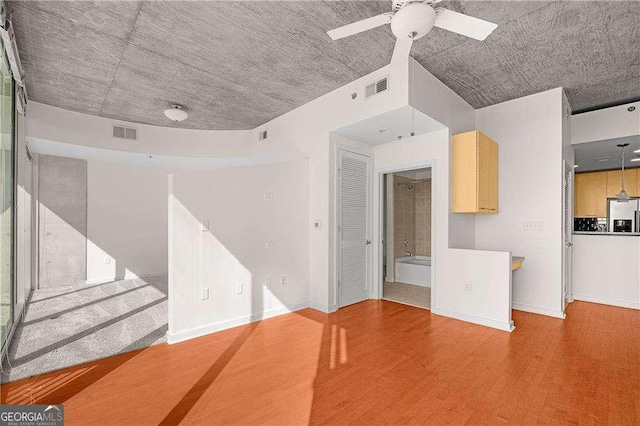 unfurnished living room featuring hardwood / wood-style flooring and ceiling fan