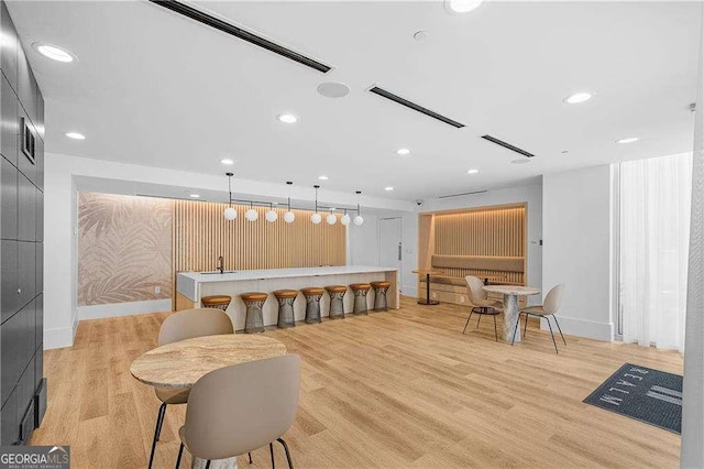 dining room featuring bar and light wood-type flooring