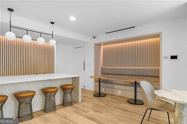 kitchen featuring a breakfast bar, pendant lighting, and light wood-type flooring