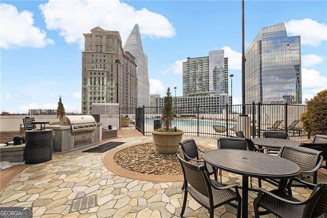 view of patio / terrace featuring an outdoor kitchen, area for grilling, and a community pool