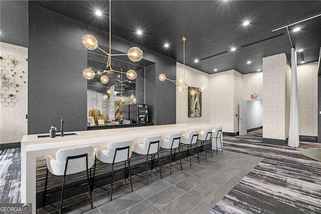 bar featuring sink and a towering ceiling