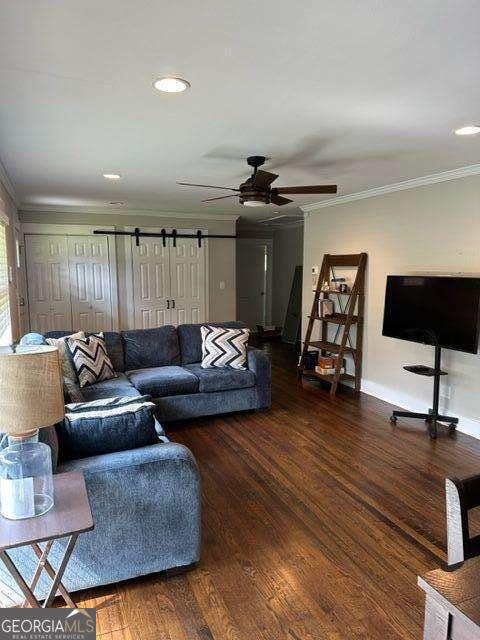 living room featuring crown molding, ceiling fan, and dark wood-type flooring