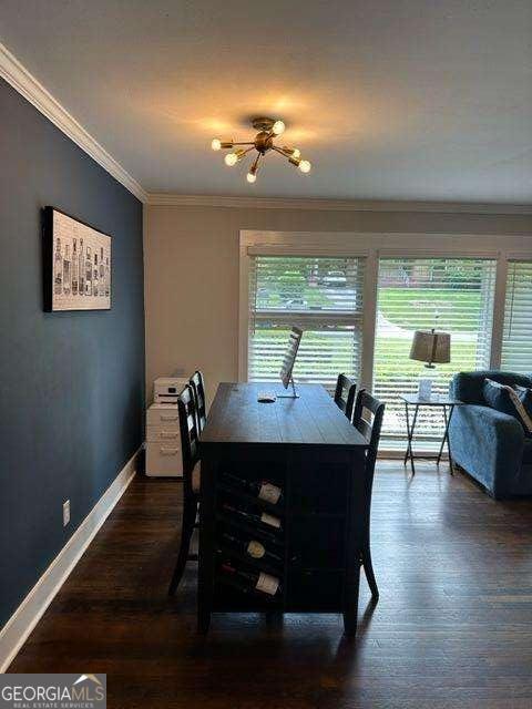 dining area featuring a healthy amount of sunlight, crown molding, and dark hardwood / wood-style floors