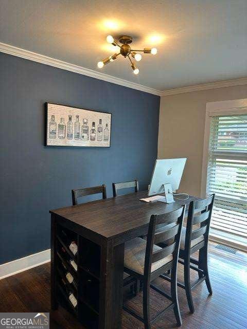 dining room with ornamental molding and dark hardwood / wood-style floors