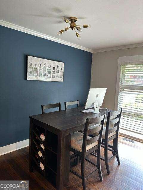 dining area with dark wood-type flooring and ornamental molding