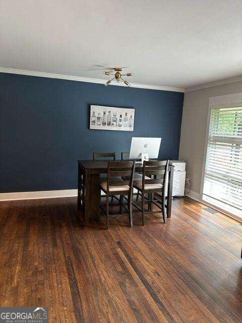 dining room with crown molding and dark hardwood / wood-style floors