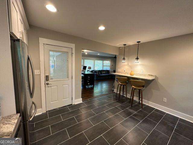 kitchen with stainless steel fridge and bar