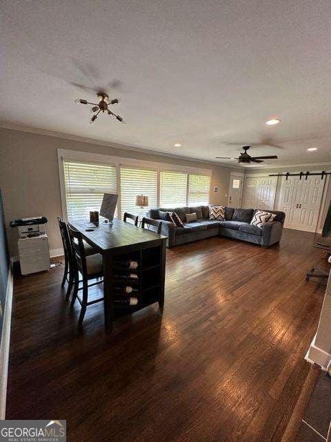 dining space with dark wood-type flooring, ceiling fan, crown molding, and a textured ceiling