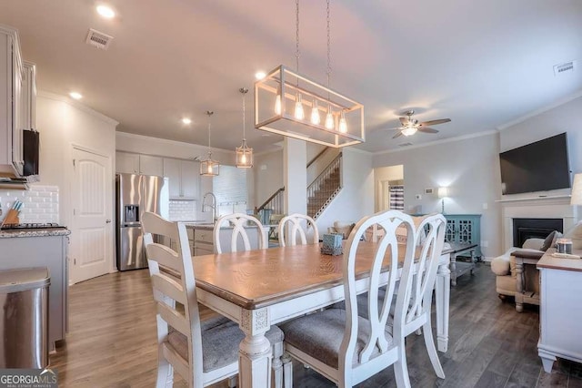 dining room with ceiling fan, ornamental molding, dark hardwood / wood-style flooring, and sink