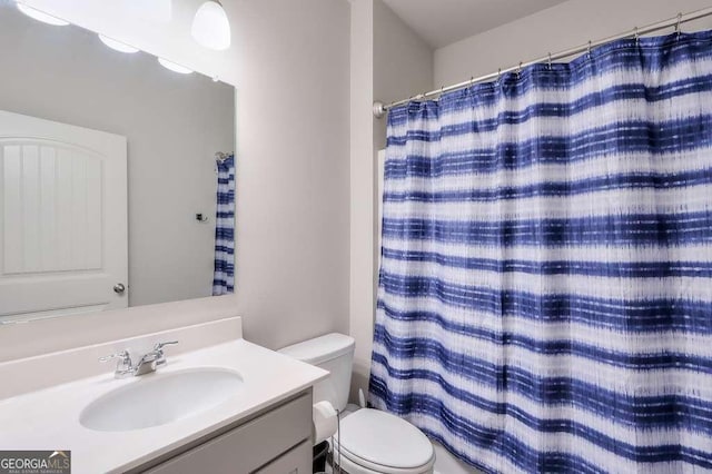 bathroom featuring a shower with curtain, vanity, and toilet