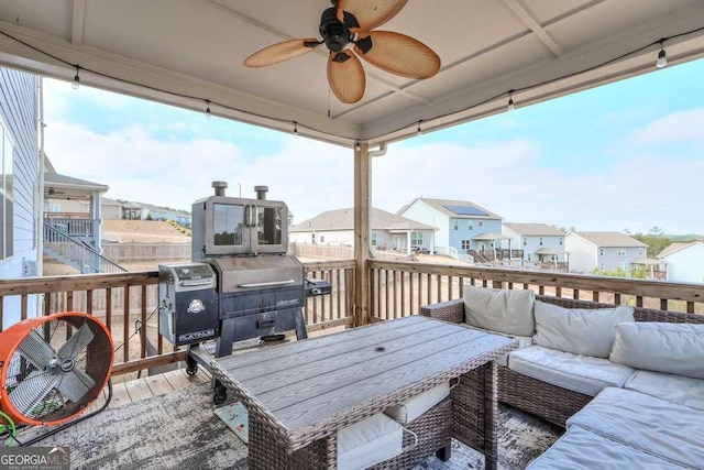 wooden deck with an outdoor living space and ceiling fan