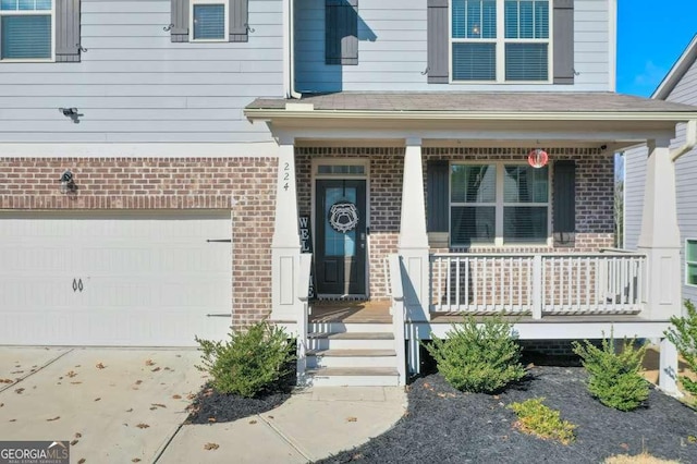 view of exterior entry featuring a garage and covered porch