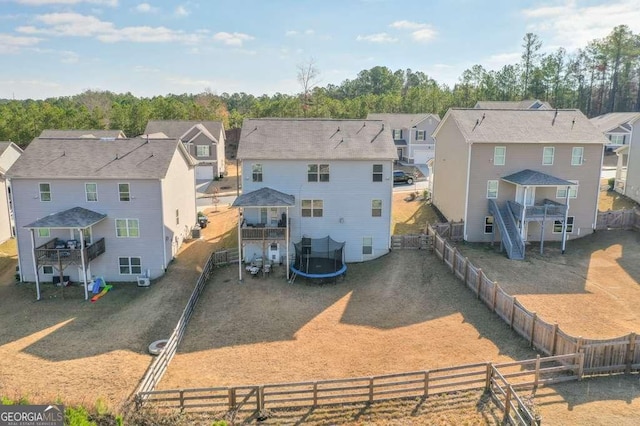 rear view of property with a trampoline