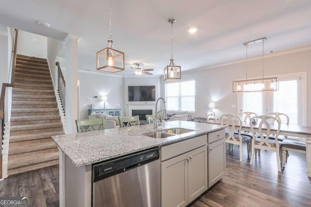 kitchen featuring a kitchen island with sink, sink, hanging light fixtures, and dishwasher