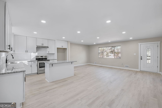 kitchen with white cabinetry, sink, a center island, electric range, and light wood-type flooring