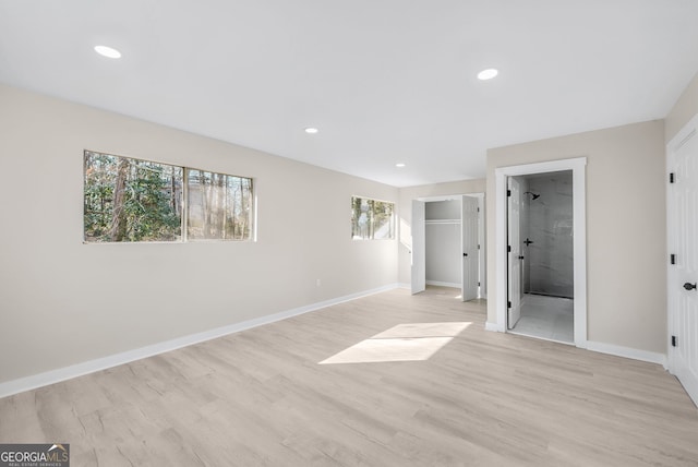 unfurnished bedroom featuring ensuite bath and light hardwood / wood-style flooring