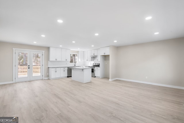 kitchen featuring sink, light hardwood / wood-style flooring, white cabinetry, stainless steel appliances, and a kitchen island