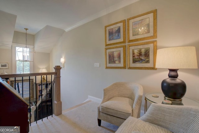 sitting room featuring an upstairs landing, a notable chandelier, baseboards, and carpet floors