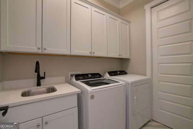 laundry area with sink, crown molding, washer and clothes dryer, and cabinets