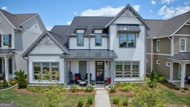view of front facade featuring a porch, board and batten siding, a standing seam roof, and metal roof