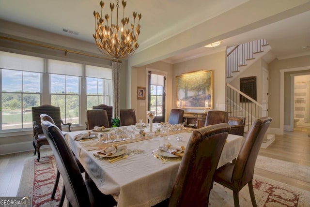 dining room with crown molding, plenty of natural light, and light wood-type flooring