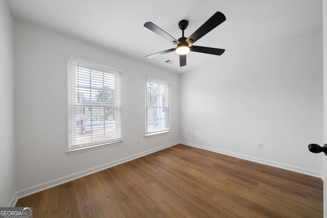 empty room with dark hardwood / wood-style floors and ceiling fan